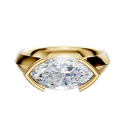 An 18K yellow gold engagement ring with a wide, cathedral knife edge band, showcasing a 4.0mm clear stone in an east/west half bezel setting for a modern look.