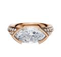 A 14K rose gold engagement ring featuring a classic knife edge and east-west bezel setting, highlighted by a single row of pave diamonds along the 2.5mm band.