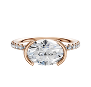 The 18K Rose Gold Bezel Half Bezel East/West Classic Dome 1-Row-Pave 2.5mm Engagement Ring features a modern half-bezel setting with a round center diamond and small accent diamonds along the band.