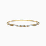 The 14K Yellow Gold Flexible Diamond Bracelet showcases a row of white diamonds on its outer surface, elegantly displayed against a plain white background.