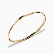 The 14K Yellow Gold Flexible Diamond Bracelet showcases a row of white diamonds on its outer surface, elegantly displayed against a plain white background.