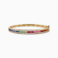 The Watercolors 14K Gold Multi Sapphire and Diamond Bangle dazzles with two diamond rows framing a central rainbow of blue, green, yellow, orange, pink, and red sapphires in a stunning gradient pattern.