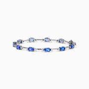 The 14K White Gold Tanzanite and Diamond Station Bracelet features vibrant oval-cut tanzanites and sparkling diamonds evenly spaced along the band, connected by delicate links for a timeless, elegant look.