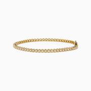 The 14K Yellow Gold 1.0 Ct. Diamond Tennis Bracelet showcases a single row of round white diamonds in individual settings, presented on a plain white background.