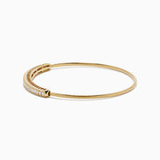 The 14K Yellow Gold Flexible Diamond Bangle features a slender design with sparkling diamonds set along the top half, shown against a white background.