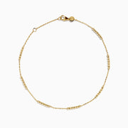 The 14K Yellow Gold Beaded Station Anklet features a delicate fine chain with evenly spaced bead clusters and a secure lobster clasp.