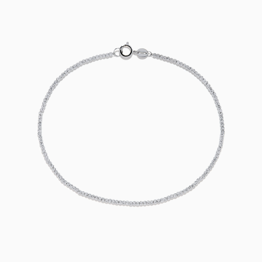 The 14K White Gold Bead Bracelet features small, evenly spaced round beads on a fine chain and includes a lobster clasp closure, displayed in a circular shape.