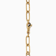 A 14K yellow gold paperclip chain bracelet featuring elongated textured links and a heart charm at the center, displayed on a white background.