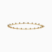 The 14K Yellow Gold Tassel Bead Chain Bracelet features small, evenly spaced round charms on a delicate chain, finished with a secure lobster clasp closure.