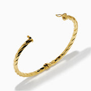 A 14K Yellow Gold Hammered Hinge Bangle featuring a textured finish, showcased on a white background.