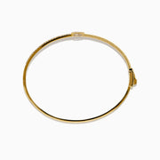 The D'Oro 14K Yellow Gold Pear Bezel Diamond Bangle showcases a row of small diamonds and a central pear bezel-set gem, all elegantly displayed against a plain white background.