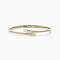 The D'Oro 14k Yellow Gold Diamond Bypass Bangle showcases two overlapping ends tipped with pear-shaped diamonds and a band lined with small round diamonds.