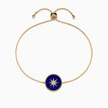 The 14K Yellow Gold Lapis and Diamond Compass Bolo Bracelet features an adjustable chain with a round lapis-inspired blue enamel center charm, adorned with a white starburst design and sparkling diamond accents.