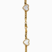 The 14K Yellow Gold Mother of Pearl and Diamond Heart Chain-link Station Bracelet features five white heart-shaped charms bordered with sparkling stones, evenly spaced along a gold chain.