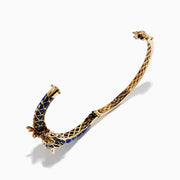 The 14K Yellow Gold Lapis, Blue Sapphire and Diamond Dragon Bangle features two dragon heads facing each other, with a blue enamel scale-inspired band, intricate gold details, and blue sapphire accents.