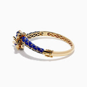 The 14K Yellow Gold Lapis, Blue Sapphire and Diamond Dragon Bangle features two dragon heads facing each other, with a blue enamel scale-inspired band, intricate gold details, and blue sapphire accents.