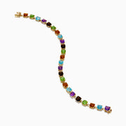 The 14K Yellow Gold Cushion Cut Multi Color Gemstone Tennis Bracelet showcases a row of cushion-cut multicolored gemstones set in yellow gold, displayed against a white background.