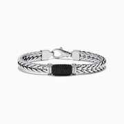 The Mens Sterling Silver Black Spinel Bracelet features a woven chain, a rectangular textured black spinel centerpiece, and a secure clasp closure, shown on a white background.