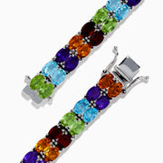 The 925 Mosaic Sterling Silver Double Row Multi Gemstone Tennis Bracelet features vibrant green, blue, purple, red, and orange stones in a dazzling repeating pattern.