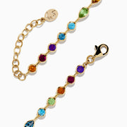 The Mosaic 14K Yellow Gold Bezel Set Multi Gemstone Adjustable Tennis Bracelet (7.0 TCW) features faceted oval gemstones in purple, blue, green, and orange hues with an adjustable clasp, shown on a white background.