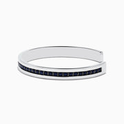 A sleek Mens 925 Sterling Silver Black Sapphire Cuff Bangle (4.09 TCW) features a single row of dark sapphires along the center, an open-ended design, polished finish, and modern appeal.
