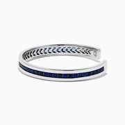 The Men's 925 Sterling Silver and Blue Sapphire Bracelet features a row of blue sapphires at the center and black chevron accents on the edges, offering a bold update to the classic blue sapphire bracelet.