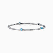 The Lab Grown Blue and White Diamond Tennis Station Bracelet in 14K white gold features clear lab grown diamonds with three evenly spaced round blue gemstones, shown displayed on a white background.