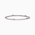 The Lab Grown Pink and White Diamond Tennis Station Bracelet in 14K White Gold features a slim band with sparkling clear stones and three larger pink and white diamonds in rose gold accents, beautifully displayed on a white background.