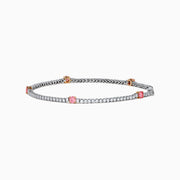 The Lab Grown Pink and White Diamond Tennis Station Bracelet in 14K White Gold features a slim band with sparkling clear stones and three larger pink and white diamonds in rose gold accents, beautifully displayed on a white background.
