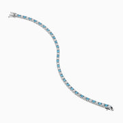 The Lab Grown Blue and White Diamond Tennis Bracelet in 14K White Gold features alternating round blue and white diamonds set in a continuous line, shown against a white background.