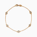 The Pave Rose 14K Rose Gold Diamond Station Bracelet features five round diamonds in gold bezels on a delicate chain with a lobster clasp, shown on a white background.