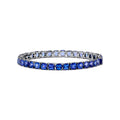 The Nahla Siri Sterling Silver Tanzanite Tennis Bracelet showcases a row of square-cut tanzanite gemstones set evenly around the band, displayed against a white background.
