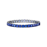 The Nahla Siri Sterling Silver Tanzanite Tennis Bracelet showcases a row of square-cut tanzanite gemstones set evenly around the band, displayed against a white background.