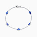The Nahla Siri 14K White Gold Tanzanite and Diamond Tennis Bracelet features five oval tanzanite gemstones set among sparkling diamond accents in a delicate design with a secure clasp.