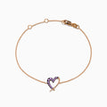 The 14K Rose Gold Multi Sapphire Heart Bracelet features a heart-shaped pendant with small purple sapphires, displayed on a white background.