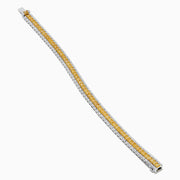 The Canare 18K Two Tone Gold White & Yellow Diamond Bracelet, showcasing a central row of yellow diamonds bordered by clear stones, is elegantly displayed on a white background.
