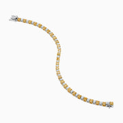 The Canare 18K White and Yellow Gold Diamond Tennis Bracelet features alternating white and yellow diamonds, elegantly displayed in a circular shape on a white background.