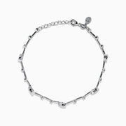 The 14K White Gold Diamond Station Bracelet features small round and teardrop-shaped diamonds spaced along a thin chain, showcased on a white background.