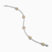 The 18K Two Tone Gold Yellow and White Diamond Station Tennis Bracelet features sparkling white diamonds and three striking yellow and white diamond stations, each outlined by smaller diamonds in an elegant, detailed design.