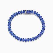 The Nahla Siri Sterling Silver Oval Tanzanite Tennis Bracelet showcases a continuous row of oval-cut tanzanite gems set in sterling silver with a sleek clasp, displayed against a white background.