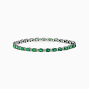 The 925 Sterling Silver Emerald and Diamond Tennis Bracelet features a continuous row of oval green gemstones and diamonds, each prong-set for elegance, reminiscent of an emerald bracelet, displayed on a white background.