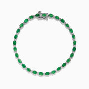 The 925 Sterling Silver Emerald and Diamond Tennis Bracelet features a continuous row of oval green gemstones and diamonds, each prong-set for elegance, reminiscent of an emerald bracelet, displayed on a white background.