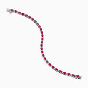 The 925 Sterling Silver Ruby and Diamond Tennis Bracelet features a continuous row of round rubies and diamonds in prong settings, elegantly displayed in a circular shape against a white background.