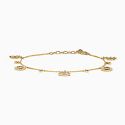 The 14K Yellow Gold Diamond Nautical Charm Bracelet features ship wheels, life rings, sparkling crystals, and a stone-adorned anchor. It includes an adjustable chain and lobster clasp for a perfect fit.