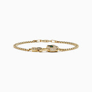 The Signature 14K Yellow Gold Diamond and Emerald Panther Cuban Link Bracelet features a panther head with green emerald eyes and sparkling diamonds on the clasp, showcased against a white background.