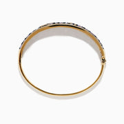 A 14K yellow gold bangle bracelet featuring tanzanite and diamond accents in a starfish design.