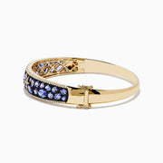 A 14K yellow gold bangle bracelet featuring tanzanite and diamond accents in a starfish design.
