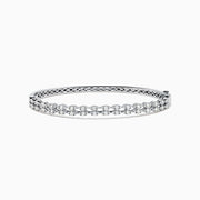 The 14K White Gold Diamond Bangle features two rows of diamonds and a delicate openwork pattern on the inner side.