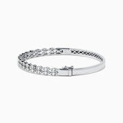 The 14K White Gold Diamond Bangle features two rows of diamonds and a delicate openwork pattern on the inner side.