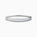 The Classique 14K White Gold Diamond Bangle features two rows of round diamonds and a central row of baguette-cut diamonds, elegantly set against a plain white background.